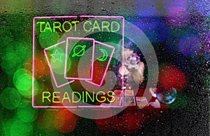 Tarot Card Readings Neon Sign in Window with Psychic Tarot Card Reader in background