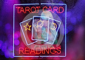 Tarot Card Readings Neon Sign in Window with Psychic Tarot Card Reader in background