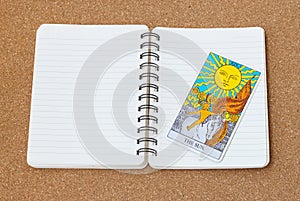 Tarot card The Sun with notebook and space.