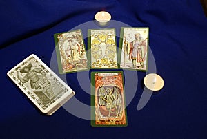 Tarot cards with candles on blue textile