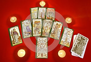 Tarot cards with candles on red textile