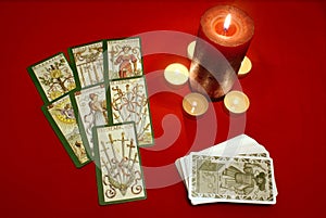 Tarot cards with candles on red textile