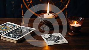 Tarot cards laid out on a table beside flickering candles, evoking a sense of mystique