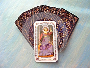 Tarot cards medieval close up with russian title Justice, Adjustment Tarot Decks on blue wooden background