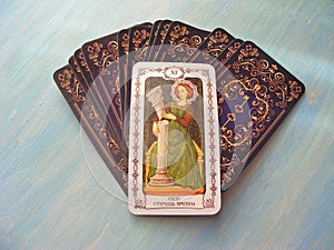 Tarot cards medieval close up with russian title Lust, Strength Tarot Decks on blue wooden background