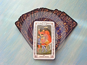 Tarot cards medieval close up with russian title The Magus, The Magician Tarot Decks on blue wooden background photo