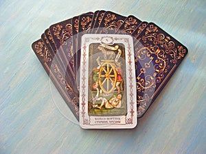 Tarot cards medieval close up with russian title Wheel of Fortune Tarot Decks on blue wooden background photo