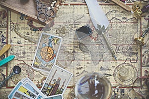 Tarot cards on the world vintage map for fortune and travel concept. Flay lays with photo