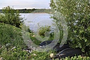 Tarred wooden boats in the bushes on the banks of the Volga River