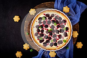 Tart with blackberry and cheesecake cream decorated with mint leaves
