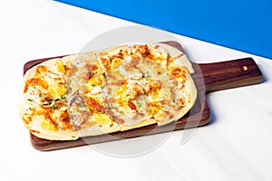 Tart flambe seafood pizza on wood board
