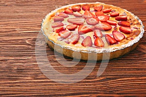 Tart with fresh strawberry on wooden background