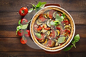 Tart with vegetables. Homemade savory tart with eggplant, zucchini, tomatoes, garlic, mozzarella cheese and fresh basil. Mediterra photo