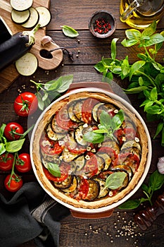 Tart with vegetables. Homemade savory tart with eggplant, zucchini, tomatoes, garlic, mozzarella cheese and fresh basil. Mediterra photo