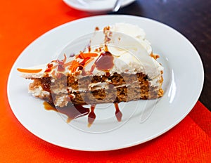 Tarta de zanahoria. Tender sweet slice of soft carrot cake with cream cheese glaze photo
