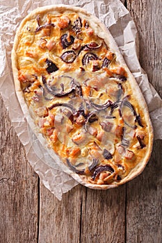 Tarte flambee on a paper. vertical top view