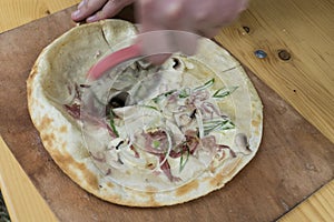 Tarte flambee while preparing with bacon, onions and cream fresh,