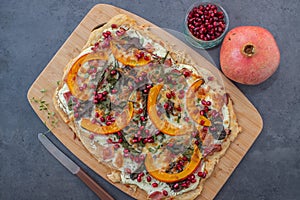 Tarte flambee with pumpkin, cheese, kale and pomegranate