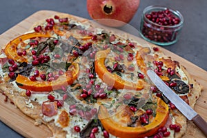 Tarte flambee with pumpkin, cheese, kale and pomegranate