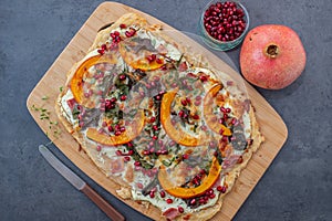 Tarte flambee with pumpkin, cheese, kale and pomegranate