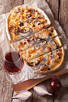 Tarte flambee sliced and red wine close-up. Vertical top view