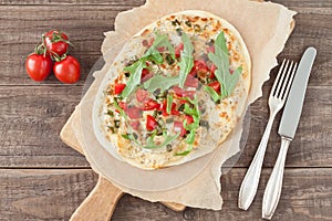 Tarte flambee with tomatoes and arugula