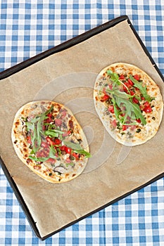 Tarte flambee with tomatoes and arugula