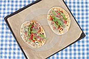 Tarte flambee with tomatoes and arugula