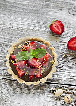 Tartlet with chocolate cream, strawberries and pistachios