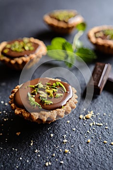 Tartlets with chocolate, pistachios and lime peel