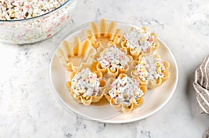 Tartlets with crab sticks, eggs, corn, poppy seeds and caviar