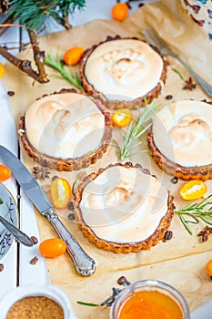 Tartlets with Kumquat Jam Filling and Meringue on the Light Wooden Table, Christmas Table Concept