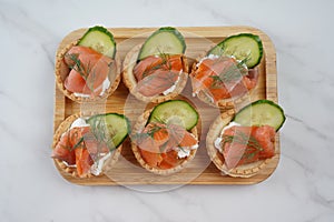 Tartlets with salmon, cheese, cucumber and dill.