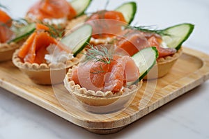 Tartlets with salmon, cheese, cucumber and dill.