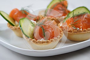 Tartlets with salmon, cheese, cucumber and dill.