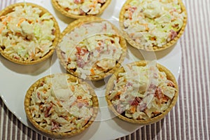 Tartlets with snack on white plate photo