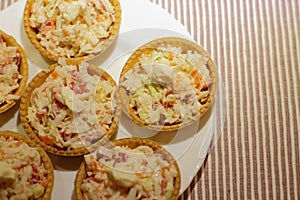 Tartlets with snack on white plate photo