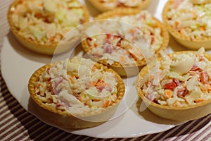 tartlets with snack on white plate photo