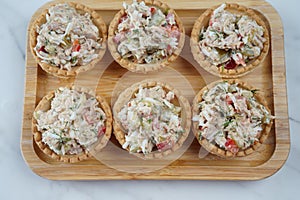 Tartlets with tuna salad, cucumber and dill.