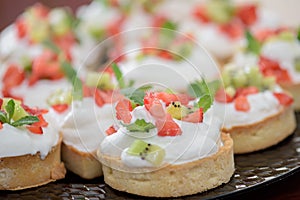 Tarts with whipped cream and strawberries and mint leaves