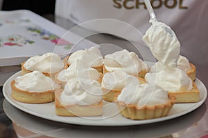 Tarts with whipped cream on a white plate