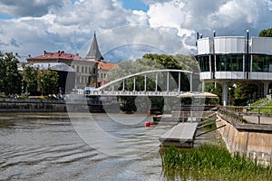 Tartu, Estonia - July 16, 2022: Arch Bridge Estonian Kaarsild over the Emajogi River and Atlantis house Estonian