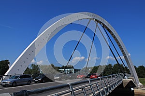 Traffic jam on Freedom bridge. High arch of the bridge against the blue sky with small clouds