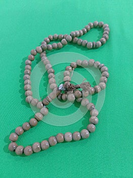 Tasbih with green cloth background photo