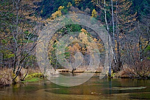 Tashiro pond surrounded by woods mountains, late autumn season in Kamikochi ,Japan