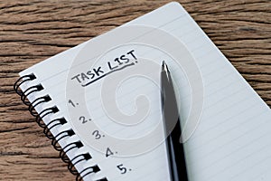 Task List, project management concept, pen on white paper notepad with handwritten headline as Task List and numbers listed on