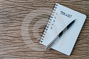 Task List, project management concept, pen on white paper notepad with handwritten headline as Task List and numbers listed on