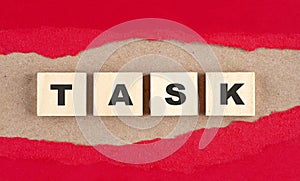TASK word on wooden cubes on red torn paper , financial concept background