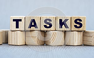 TASKS - word on wooden cubes on a beautiful gray background photo