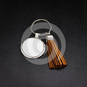 Tassel key ring on black leather background. Fashion leather key chain for decoration